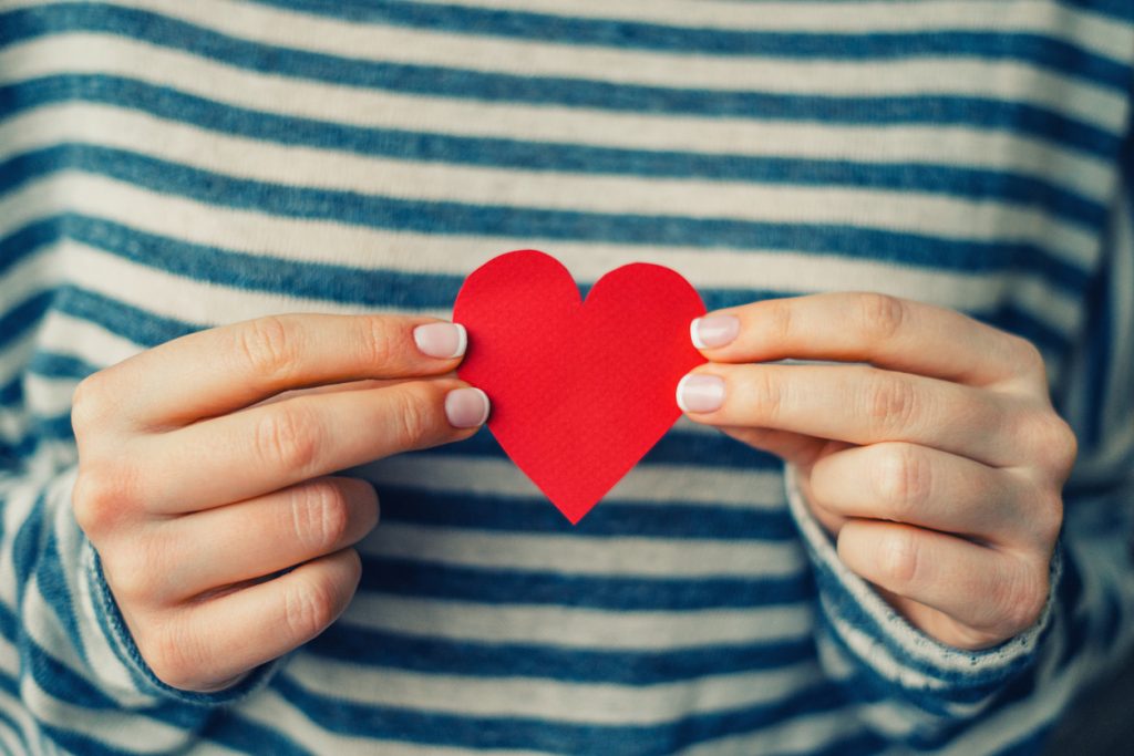 Woman holding red paper heart - Marketplace Health Insurance